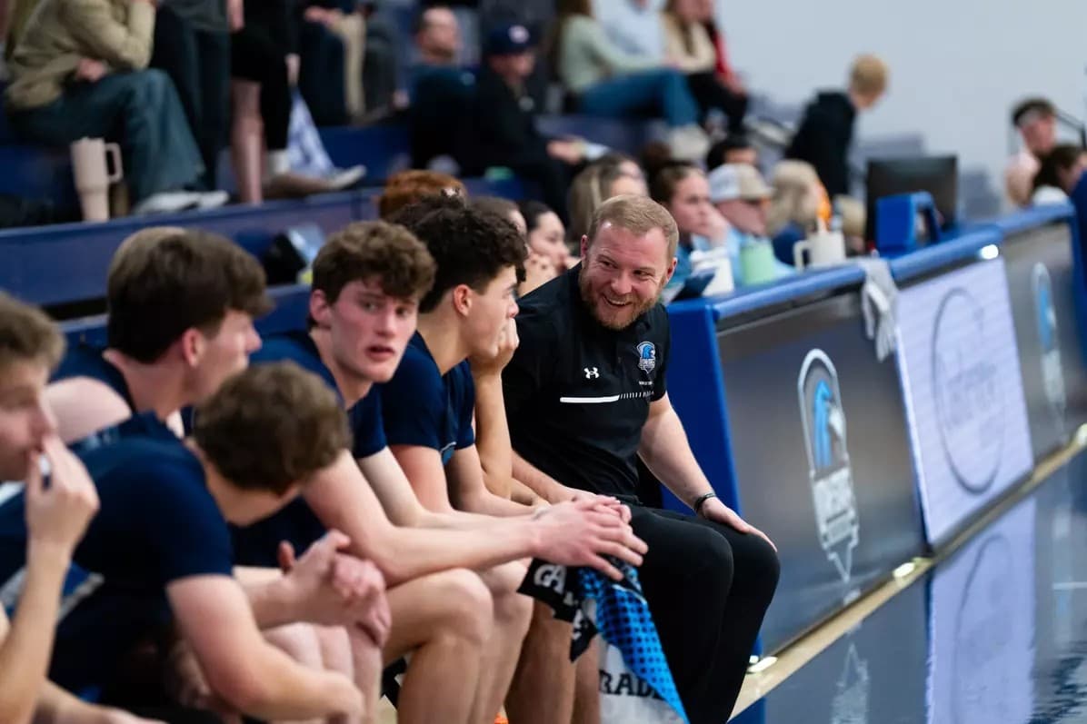 Easton Ralphs speaks with USU Eastern men's basketball players during a game.