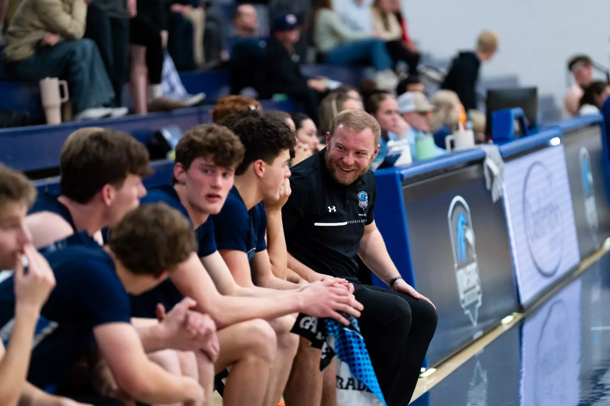 Easton Ralphs speaks with USU Eastern men's basketball players during a game.